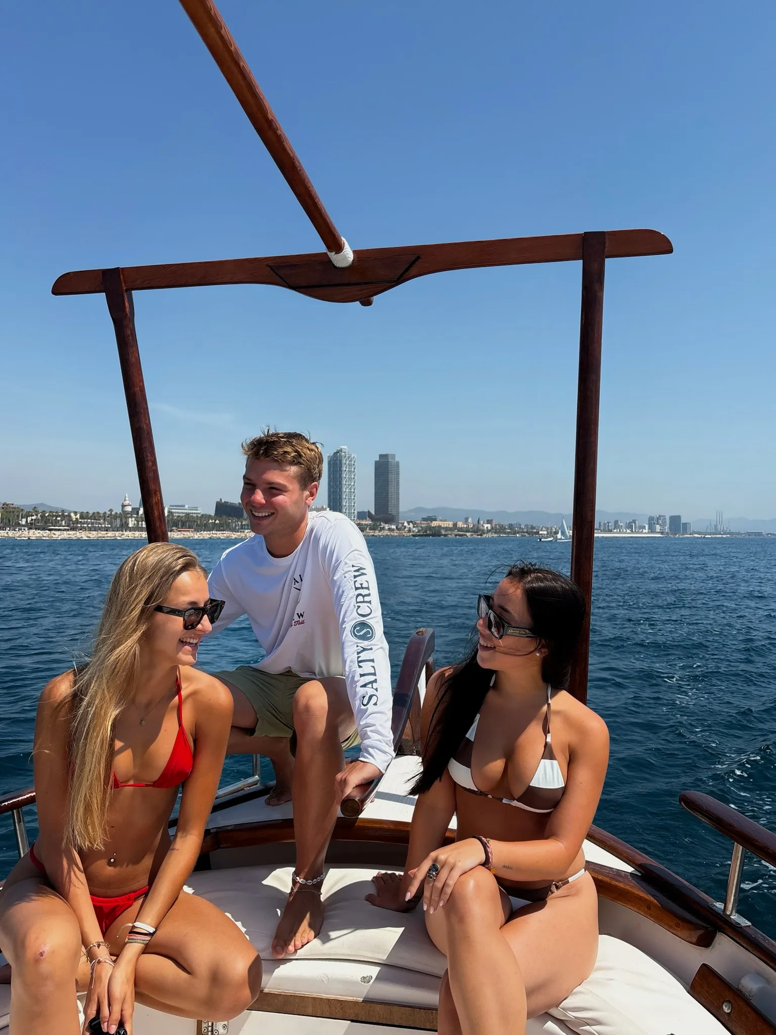 Two girls enjoying the sun and the sea with the boat captain.